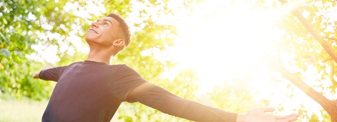 Coureur en plein air pratiquant la respiration abdominale au soleil pour améliorer son endurance et courir plus longtemps.