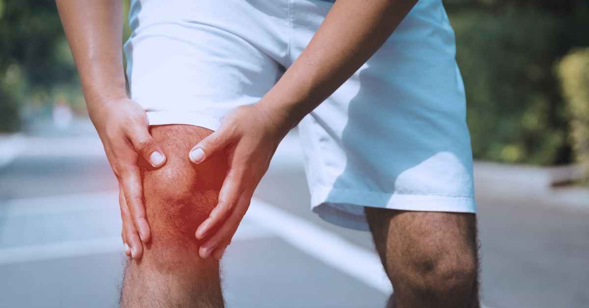 Coureur ressentant une douleur au genou pendant une course à pied sur route