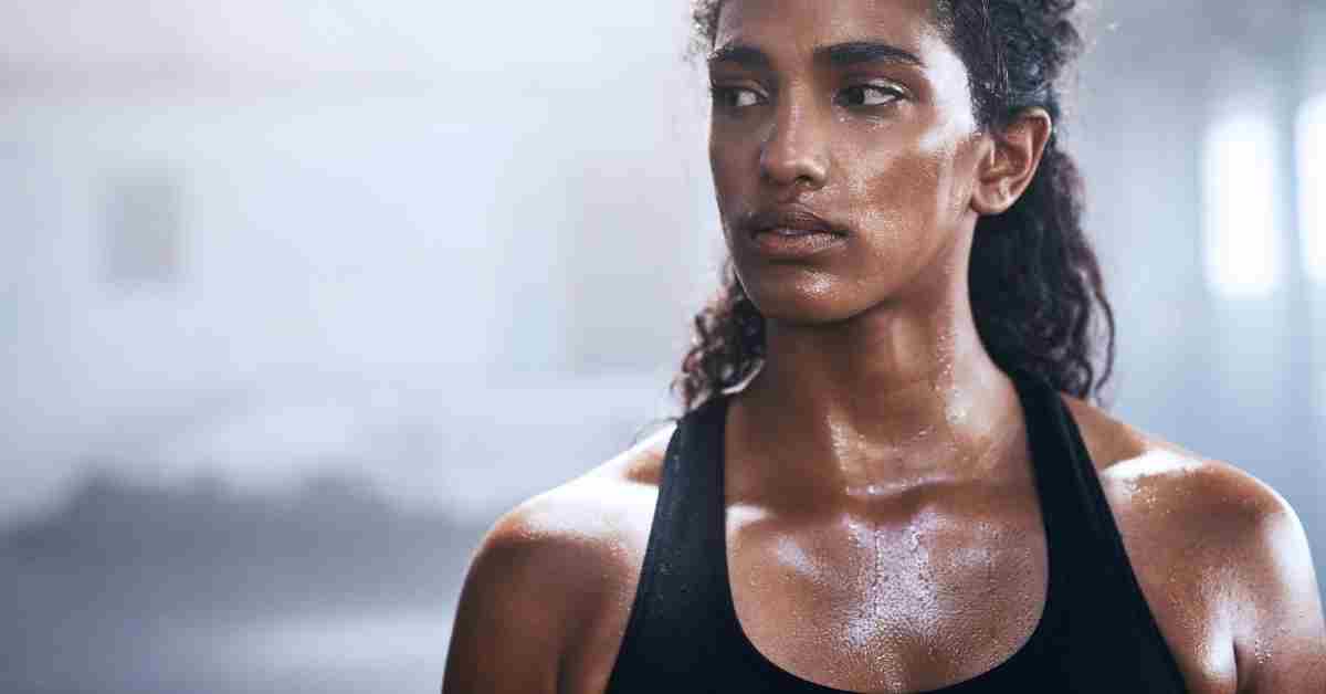 Femme sportive en brassière respirante avec transpiration après une séance de fitness intense